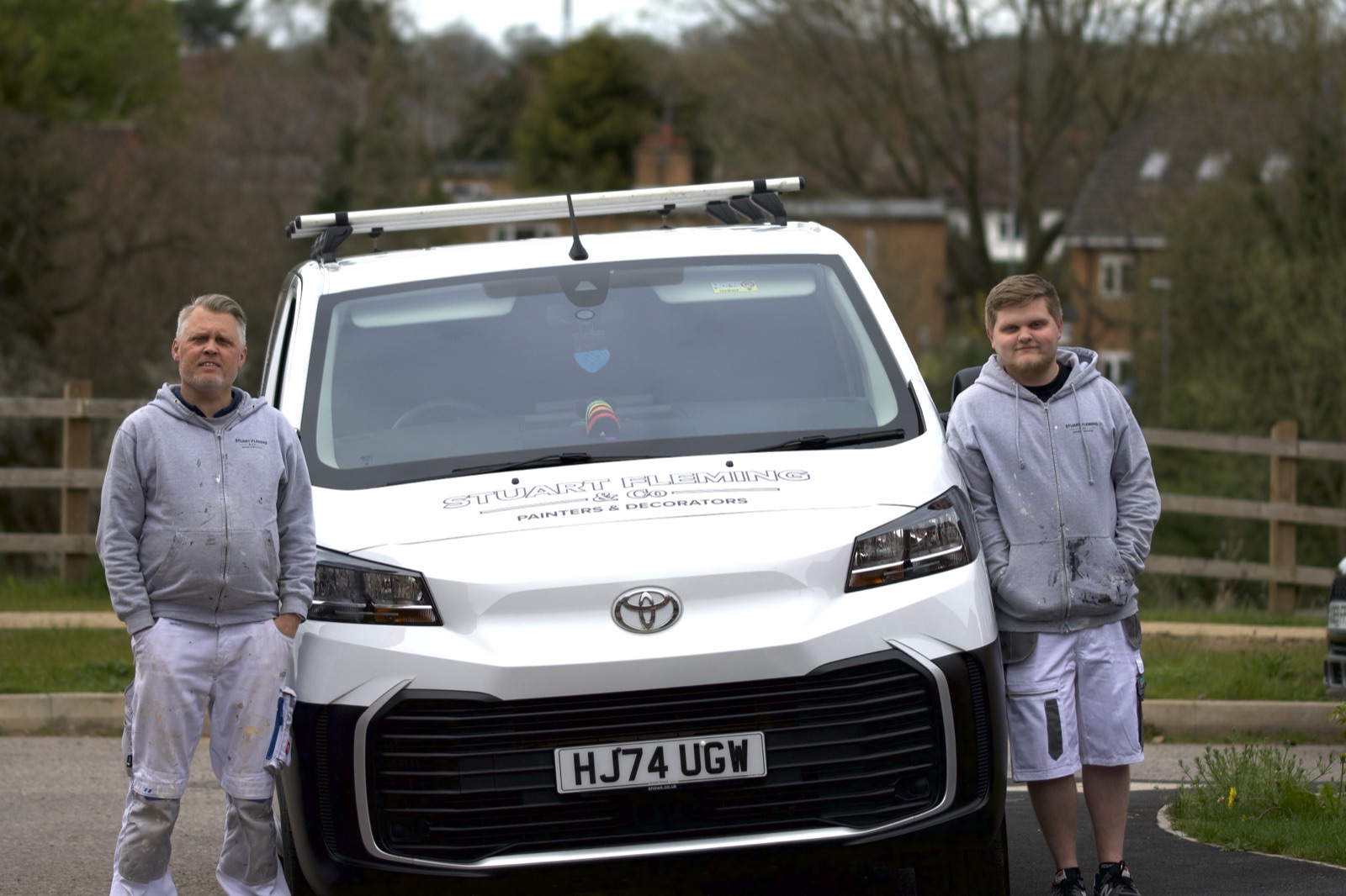 Stuart and Daniel Fleming standing with their work van